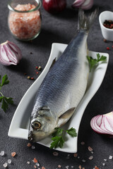 Salted herring with red onion, peppers, sea salt and parsley on gray background. Vertical format