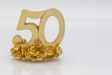 Fifty in gold for golden wedding or anniversary, birthday on white background for invitation or greeting with copy space