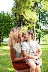 Fototapeta premium young pretty mother walking with little cute daughter outside in green park, lifestyle poeple concept