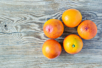 Blood Sicilian oranges on wooden cutting board. ripe juicy citrus fruits on rustic background. Top...