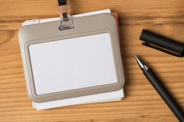 Top view photo of empty id card and pen on isolated wooden background with copyspace