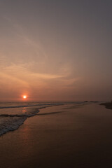 Krajobraz zachodu słońca nad brzegiem oceanu, plaża i nastrojowy widok.