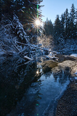 Sunburst with a frozen creek in winter.