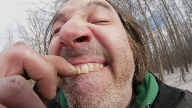 Funny and disgusting man trying to get stuck food from his teeth