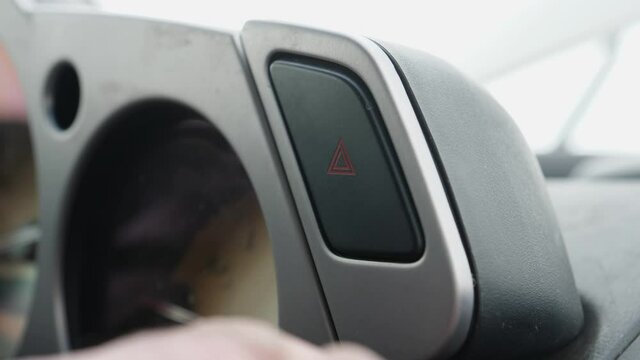 Pressing the hazard emergency button on the car to turn the 4 flashers on and warn other drivers
