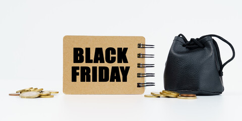 On a white background lies a bag with money, coins and a notebook with the inscription - BLACK FRIDAY