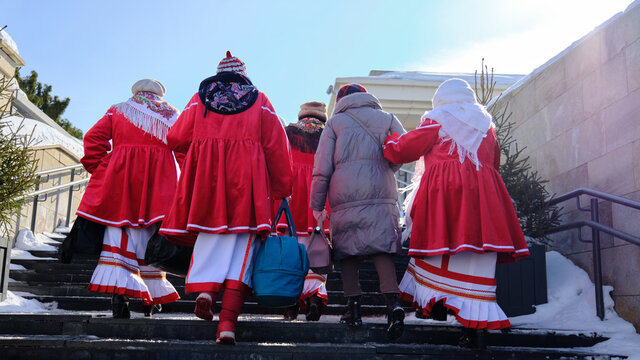 back view of Chuvash woman in red traditional suits and costumes. Russian celebration of Maslenitsa.