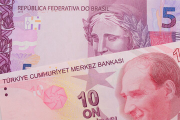 A macro image of a pink and purple five real bank note from Brazil paired up with a red, ten lira bank note from Turkey.  Shot close up in macro.
