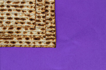 A close-up of three matzahs - bread for the Jewish Passover, on a purple background