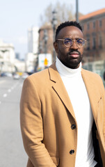 African american man looking forward and walking in a street in Madrid.