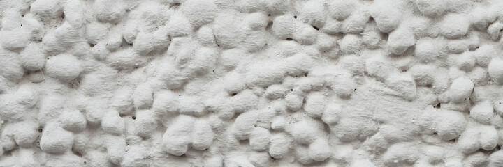 The texture of the gray wall. Decorative plaster.  Rough grainy bumpy surface. Wide panoramic texture for background and design.