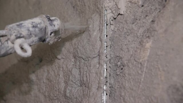 Plastering mortar machine. Automatic plaster. Repairing or renovating house or apartment. Builder at construction