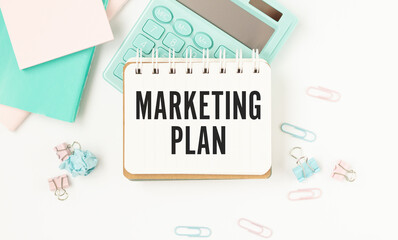 Mans hand drawing Marketing Plan concept on white notebook
