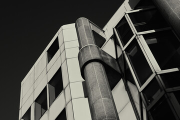 Black and white monochrome exterior of 1980s office building with graded high contrast