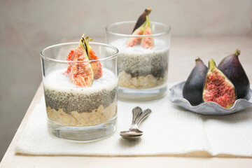 Chia seed pudding breakfast glass portions with freh figs and plant based milk. Healthy food. Lifestyle