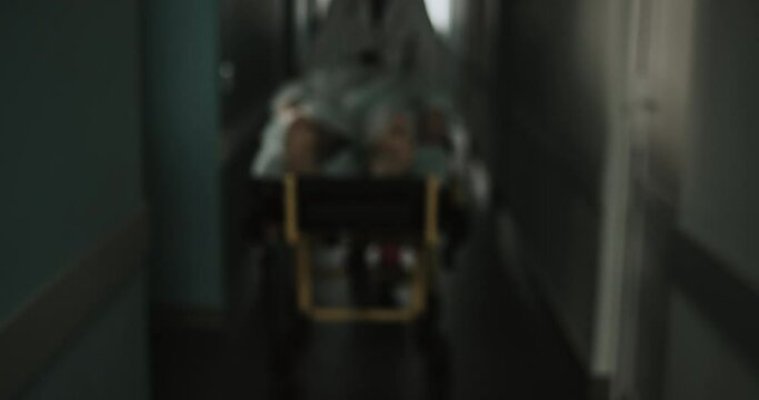 Emergency Department: Doctors Move Seriously Injured Patient Lying on a Stretcher Through Hospital Corridors. Medical Staff in a Hurry Move Patient into Operating Theater. 4k 