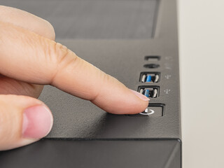 Finger is ready to press down the On Off button on the personal computer system unit. Power button...