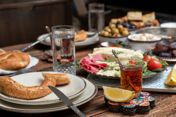Delicious rich Traditional Turkish breakfast include tomatoes, cucumbers, cheese, butter, eggs, honey, bread, bagels, olives and tea cups. Ramadan Suhoor aka Sahur (morning meal before fasting). 