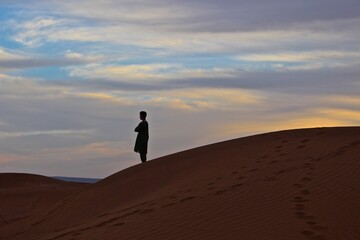 Fototapeta na wymiar Silhouette of berber at Sahara desert, Morocco, Northern Africa. Please note person on the photo is not recognizable. 