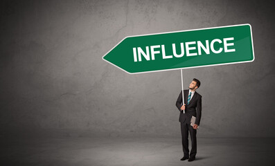 Obraz premium Young business person in casual holding road sign