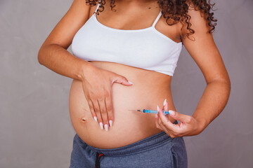 Pregnant Afro woman getting injected to prevent various problems, vaccine for pregnant women.