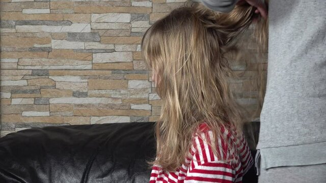 Hair drying process. Mom hands dries hair with hairdryer of cute beautiful blonde daughter. Hair care.
