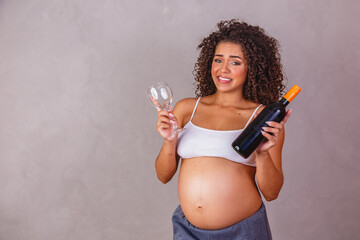 Pregnant African woman holding a glass of wine criticizing the practice of drinking alcohol, and...