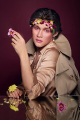 portrait of a young man of Asian appearance with flowers on his head.flowers boy