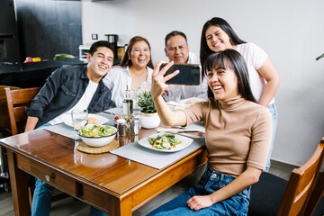 mexican family taking a photo Selfie as they enjoy meal at Home Together in Latin America