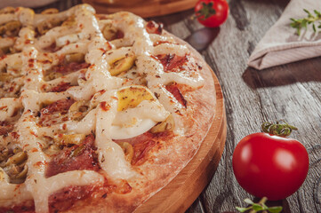 Pizza with mozzarella, calabrese sausage, eggs, catupiry, olive and oregano (Pizza especial de calabresa) - Closeup.