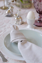 A linen napkin on a plate, tied in a knot. Decorative knot on a dinner napkin. How to Fold a Napkin.