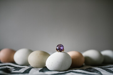 Lined up eggs with an amethyst ring