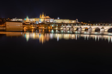 Fototapeta premium .view of the illuminated Prague Castle and the Cathedral of St. Vitus and Charles Bridge on the Vltava River at night in the center of Prague in the Czech Republic