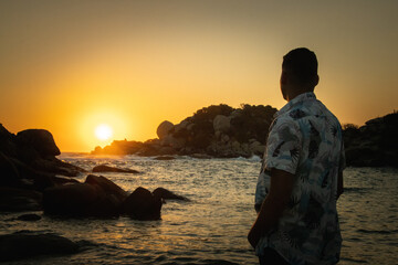 Hombre en la playa viendo el atardecer