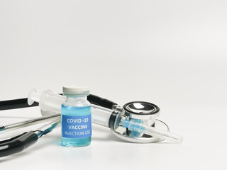 Selective focus COVID 19 VACCINE with syringe and stethoscope isolated on white background.  
