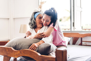 Obraz premium Portrait of enjoy happy love asian family senior mature mother and young daughter smiling laughing embracing and having fun hug together in moments good time at home