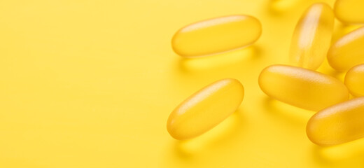 Horizontal banner with close up Omega 3 capsules on yellow background. Fish oil softgels. Copy space for your text - Image