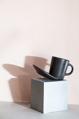 Minimal modern still life with levitation of a cup of coffee. Creative composition with geometric shape cube and coffee cup