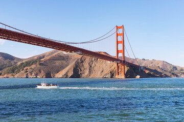 Barco turístico pasando por debajo del Golden Gate Bridge.