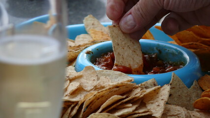 close up of nachos in salsa dip