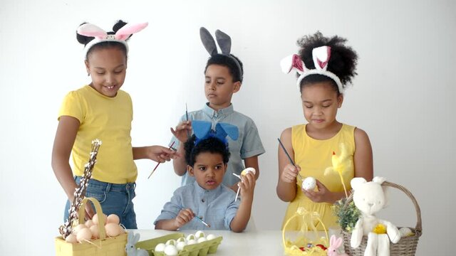 children having fun and coloring ester eggs