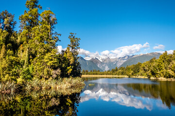 The Southern Alps reflecting in Matheson Lake. South Island, New Zealand.