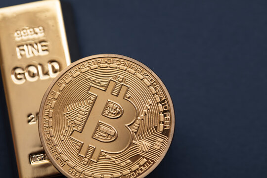 Bitcoin cryptocurrency coin with a gold bullion bar. Investment concept