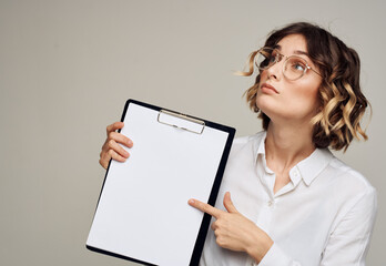 Portrait of a woman in a classic suit with a folder of documents on a gray background Copy Space