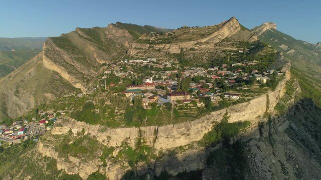 Aerial sideways Gunib Dagestan aul village, old authentic traditional settlement on plateau high in mountains. Famous travel inspirational landmark. Russia best place. Summer sunny epic nature. Stock