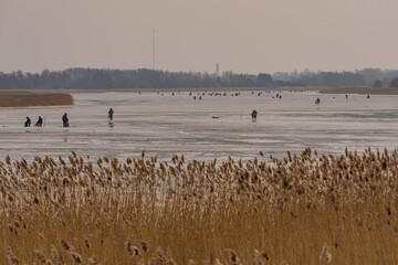 frozen river, bent and icy anglers