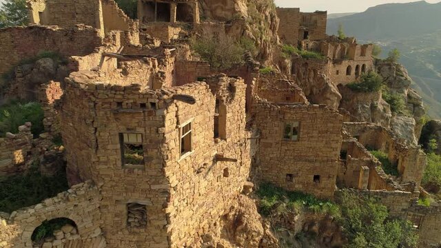 Medieval stone ruins of an ancient city on top of mountain archaeological heritage of ancestors Caucasus Dagestan Russia. Gunib aul city of dead abandoned settlement. Aerial close up details. Landmark