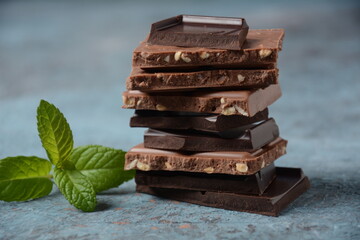 Chocolate tower. Stack of chocolate pieces. The chunks of broken chocolate. Background with chocolate.