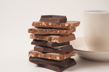 Chocolate tower. Stack of chocolate pieces. The chunks of broken chocolate. Background with chocolate.