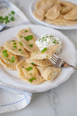 Obraz premium Pierogi ruskie, Baked dumplings stuffed with curd cheese and potatoes